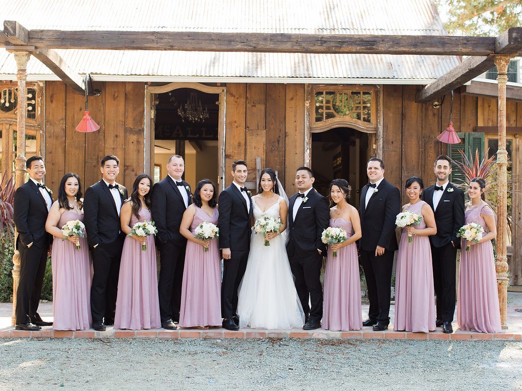 Triple S Ranch former dairy barn now reception room. Bridal Party posing in front of unique doors