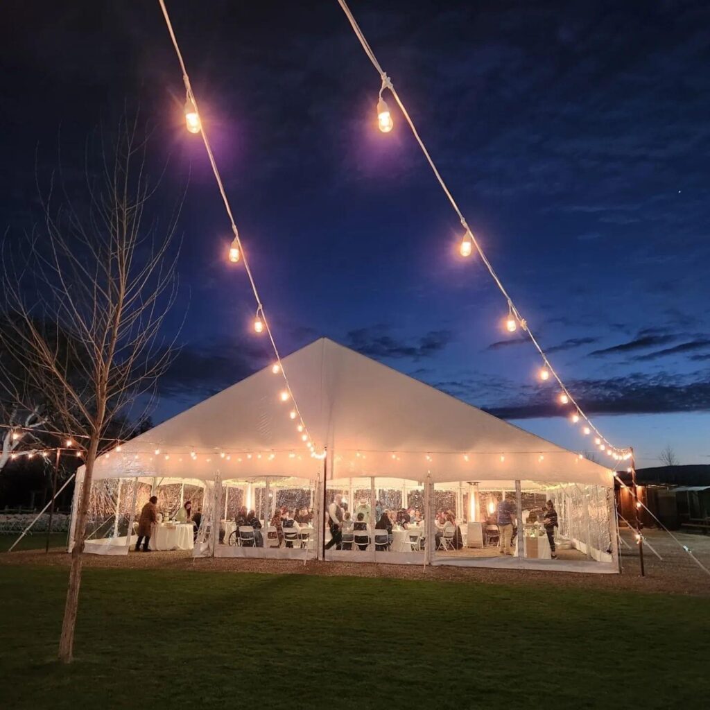 Crossing at Thomes Creek Wedding Events, Corning. Tent and market lights at night..