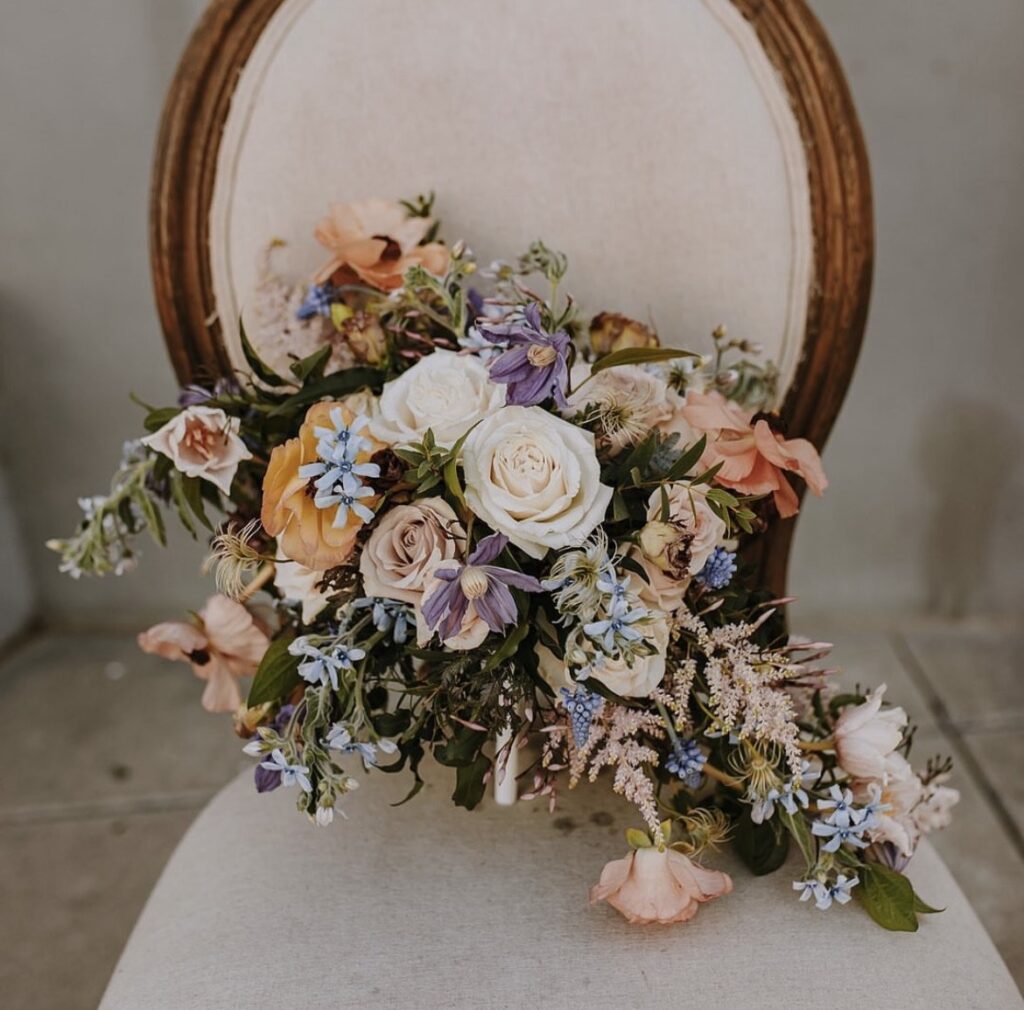 Strelitzia Flower Company. Bridal Bouquet sitting on vintage chair.